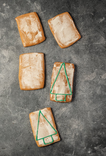 黑色的桌子上放着各种各样的圣诞姜饼和面粉图片下载