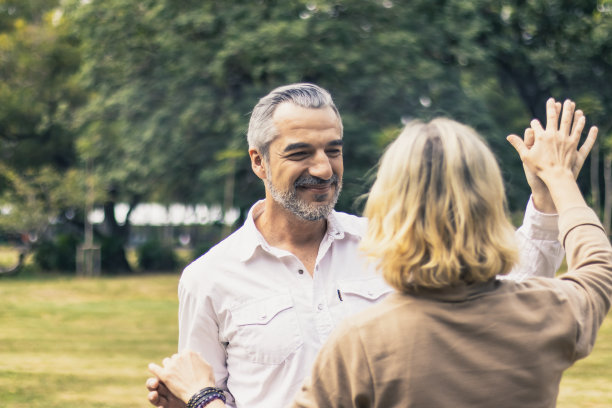 可爱的老夫妇微笑着在公园里跳舞的浪漫时刻。温暖的婚姻和爱人的纽带和关系。夫妻恩爱。快乐退休人士照片图片下载