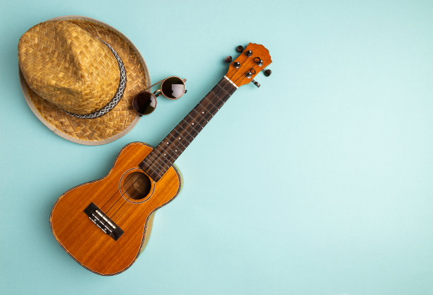 夏季度假概念与四弦琴和草帽在抽象蜡笔绿松石背景与复制空间图片下载