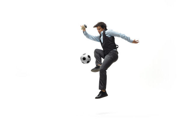 穿工作服的男人在踢足球或足球上的白色背景。不寻常的商业活动，行动。运动,健康的生活方式。图片下载