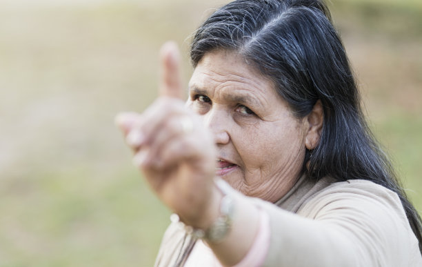 年长的西班牙裔妇女指着摄像机图片下载
