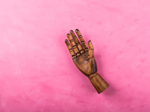 黑色的木手，摊开的手掌是粉红色的图片下载