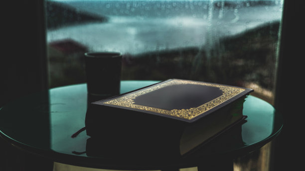 一张下雨天海边一所房子的桌子上放着一本伊斯兰教书籍的照片图片下载