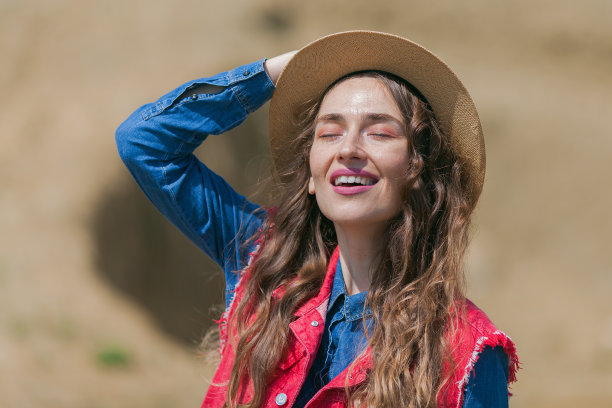 戴着帽子的年轻女子在户外享受阳光图片下载