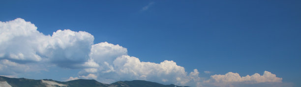 明亮的白云映衬着群山蓝天，视野开阔。图片下载