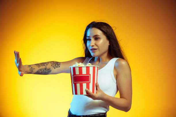 年轻的白人妇女的肖像孤立在梯度黄色工作室背景图片下载