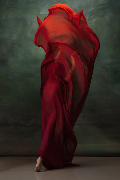 年轻优雅温柔的芭蕾舞女演员在深绿色的工作室背景图片下载