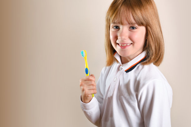 女孩在侧面显示牙刷孤立棕色图片下载