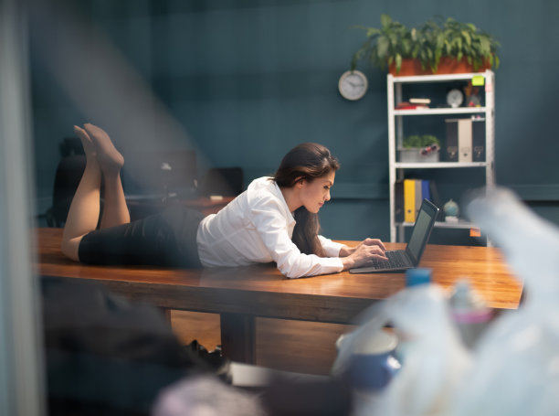 女商人工作时把笔记本电脑放在桌子上或工作场所。透过玻璃的侧视图。生活方式的概念。彩色图像图片下载