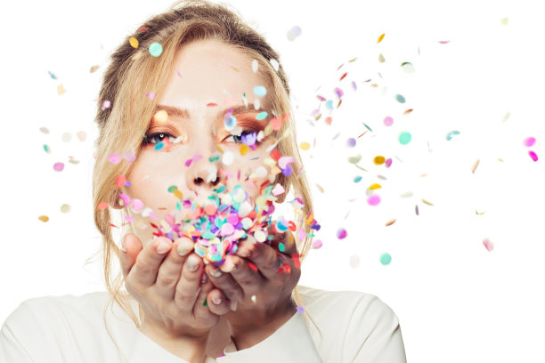 美丽的女人吹彩色的飘落的五彩纸屑孤立在白色的背景图片下载