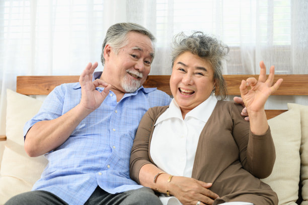 健康的亚洲夫妇坐在客厅沙发上的肖像照片，表现出快乐或健康的生活方式高级概念。图片下载