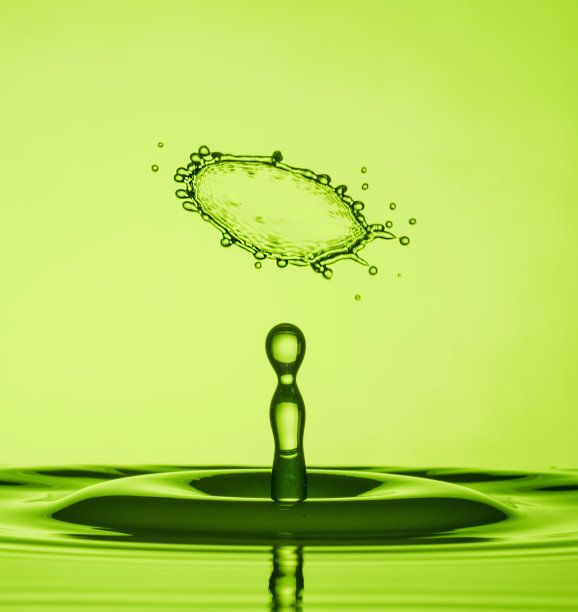 水滴碰撞微距摄影与绿色背景图片下载