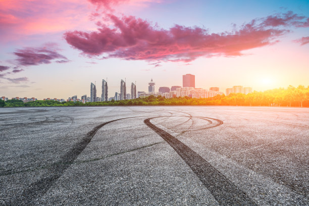 夕阳下的上海，沥青赛道和城市天际线上的建筑物。图片下载