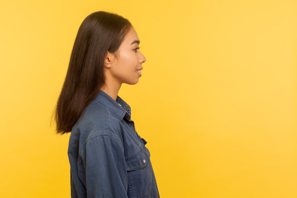 侧面快乐积极的女孩在牛仔衬衫与直黑发微笑，对生活感到满意图片下载