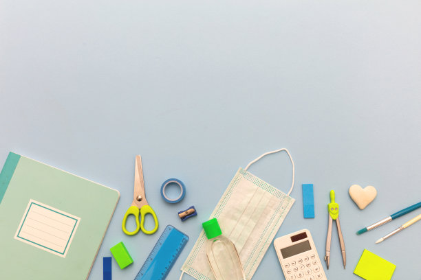 学校的冠状病毒传播预防措施。医用口罩，酒精消毒凝胶和淡蓝色背景文具，图片下载