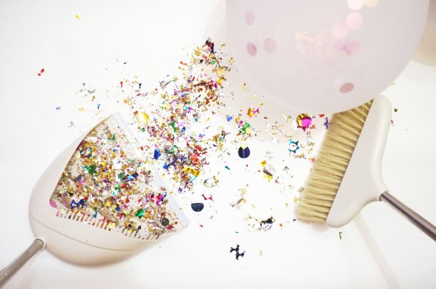 在白色背景上的扫帚的特写。聚会或庆祝活动后清扫五彩纸屑。白色背景或地板上散落着五颜六色的五彩纸屑。派对结束后，用猪鬃扫帚清扫垃圾图片下载
