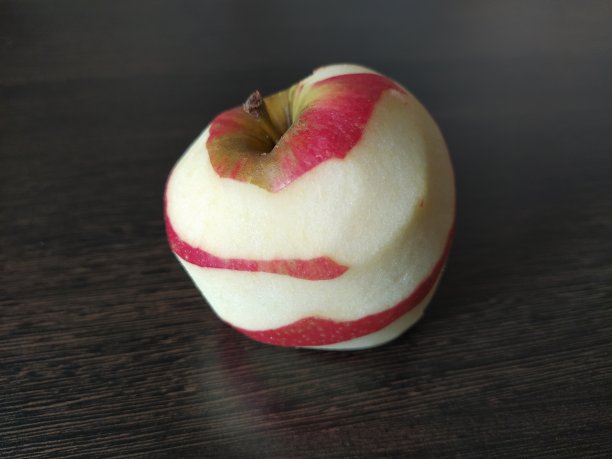 桌子上有去了一半皮的红苹果图片下载