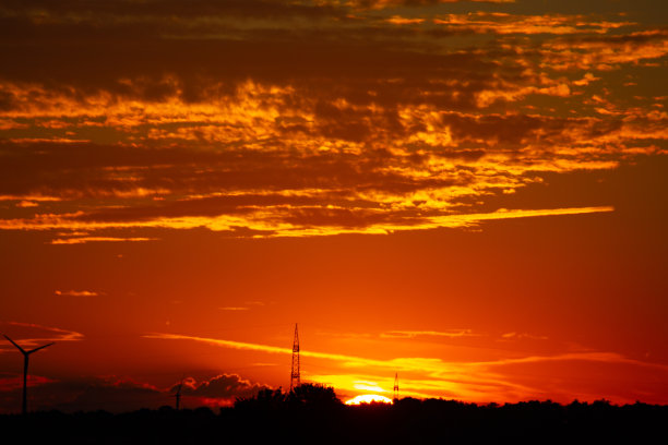 日出与地平线上风力涡轮机的剪影图片下载