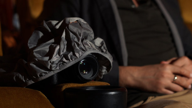 一个男人一边看电影，一边偷偷地拍电影。图片下载