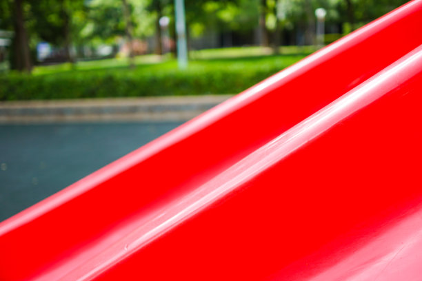 红色滑梯的特写。五颜六色的儿童游乐场。公园里的游乐设备。主题在右边。图片下载