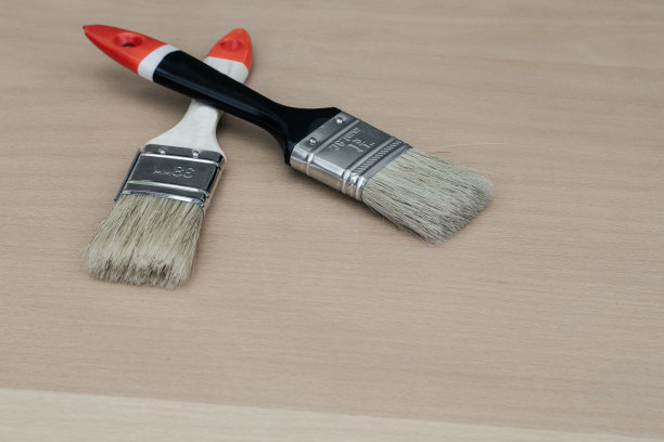 油漆工作的工具。抹刀和刷子。成套维修项目。顶部视图的一个建设者与刷子和抹刀应用腻子上的木材。图片下载