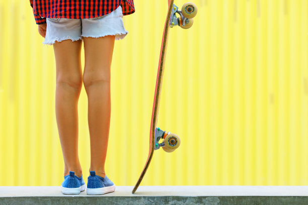 滑板腿的近视图，运动鞋，滑板。图片下载