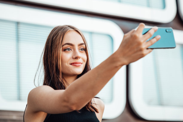 都市自拍微笑女人用手机自拍图片下载