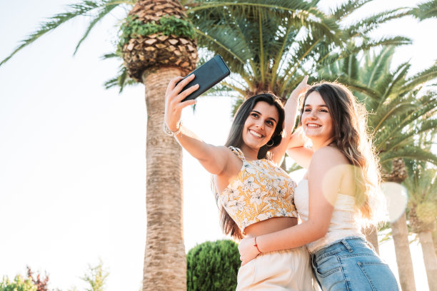 两个年轻的女人朋友有乐趣在公园自拍图片下载