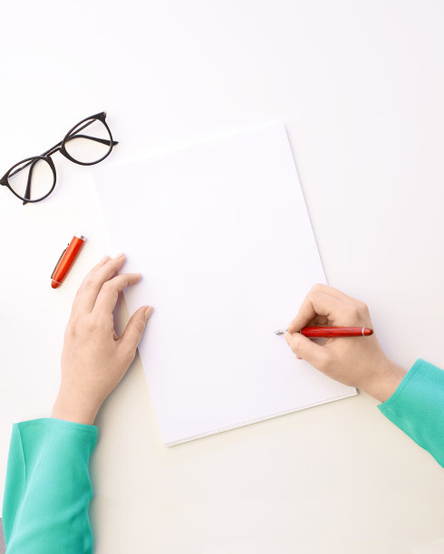 俯视图中女性的手正在白纸上写字图片下载