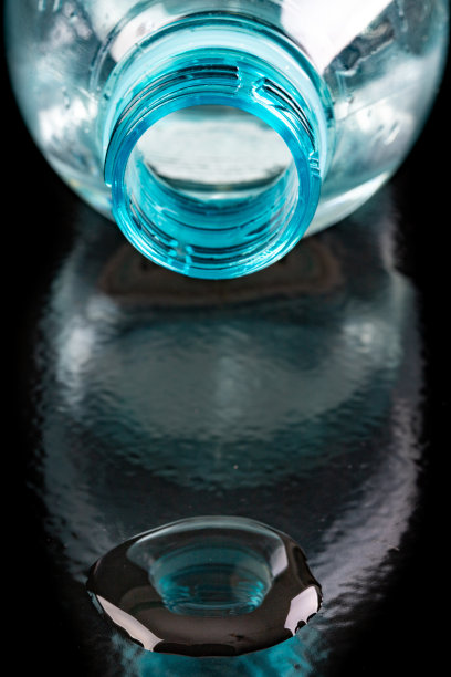 塑料瓶口和水。水储存容器。黑暗的背景。图片下载