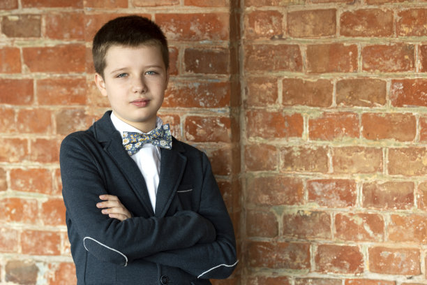 一个自信的男孩的肖像，10岁，穿着西装和领结。图片下载