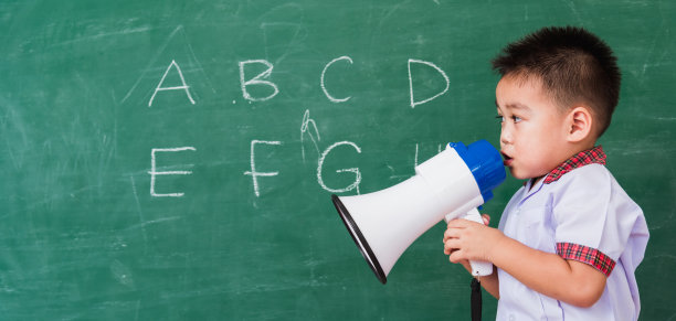 幼稚园男孩穿着学前班校服，通过扩音器说话图片下载