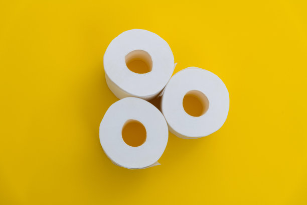 三卷黄色背景的白色厕纸图片下载