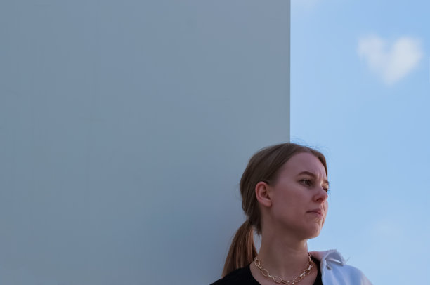 一个现代金发女孩的户外肖像。把目光移开。华尔街和蓝天。副本的空间。随意的风格图片下载