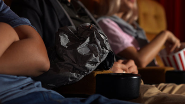 一个男人一边看电影，一边偷偷地拍电影。图片下载