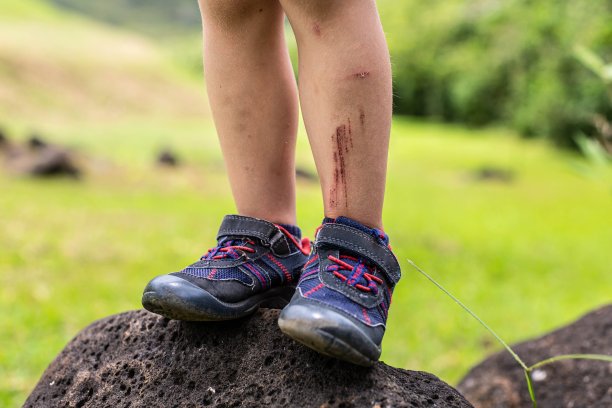 近距离的一个小男孩泥腿站在一个大的岩石在徒步旅行图片下载