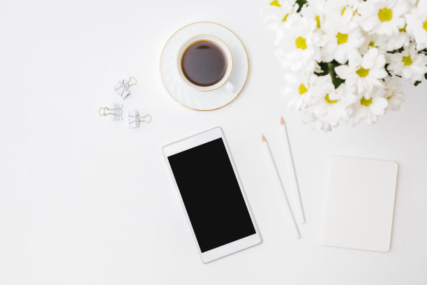 平躺的智能手机模型空白屏幕，白色的花朵，一杯咖啡在白色的背景图片下载