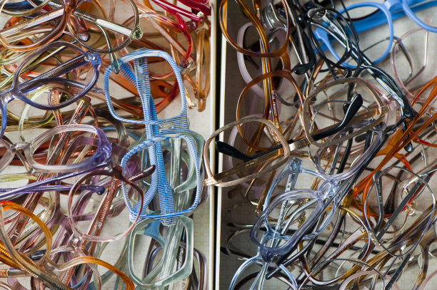 老式的眼镜。各种彩色，充满活力的黑色眼镜和眼镜框架拍摄在彩色和白色的背景。在验光师办公室和眼镜商店可以买到经典的眼镜产品照片。图片下载