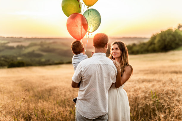 快乐的年轻家庭在田野上。图片下载