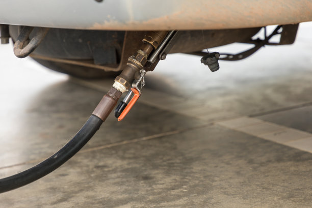 汽车加油。在加油站加油的汽车。汽车正在用油嘴、液化气服务泵来填充液化石油气。替代能源的概念。往车上加石油气图片下载