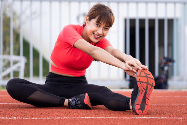一个年轻女子跑步的肖像热身和拉伸在早上锻炼前。健康和娱乐库存照片。图片下载