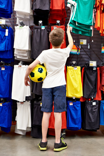 足球服装店里拿着球的男孩图片下载