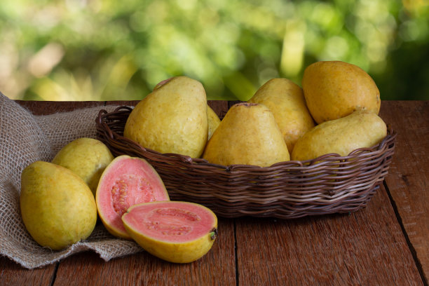 番石榴水果在木背景和模糊的花园背景切篮子的照片图片下载