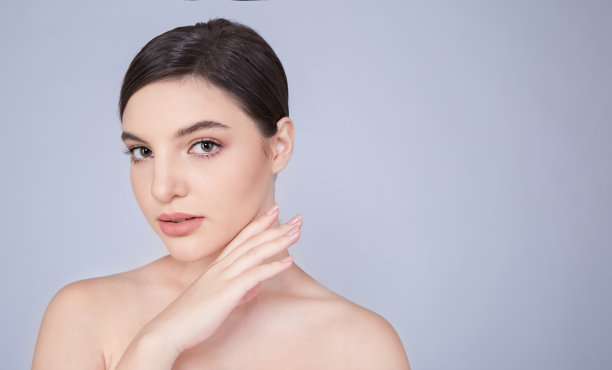 特写的白人妇女与公平完美的健康容光焕发的皮肤化妆，年轻美丽的女孩与漂亮的微笑在脸上手触摸皮肤。美容诊所护肤spa模特时尚概念横幅图片下载