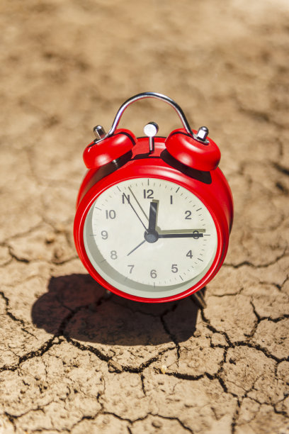 干涸土壤中闹钟的概念照片：裂缝、失效、死亡、沙漠、土壤、表面、地面、背景、灾难、环境灾难图片下载