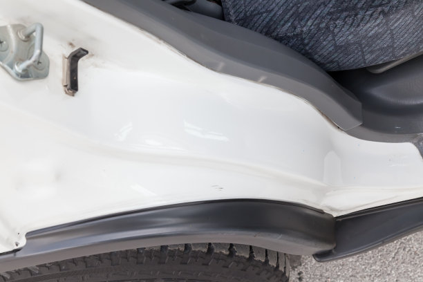 一个白色金属拱门的特写，一个日本SUV车身车轮在一个停车场，机翼后拉直和油漆后的俯视图。图片下载