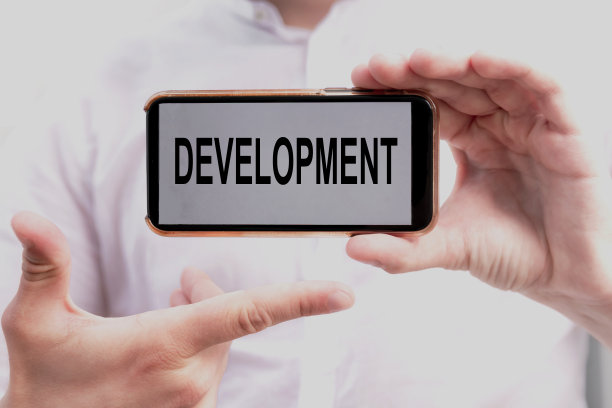 文字发展在屏幕上的智能手机在商人手中的白衬衫。经营理念图片下载