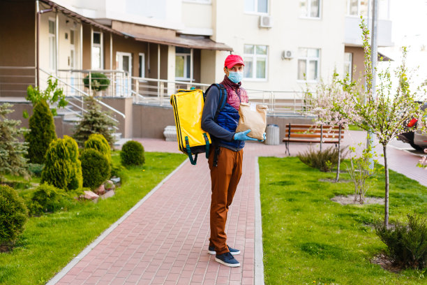 非接触式食品送货上门。带保温背包的快递员从餐厅、超市或咖啡馆快速送出被隔离的食物。在线订购食物图片下载