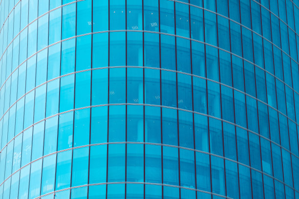 由蓝色调的玻璃窗制成的摩天大楼的现代立面。图片下载
