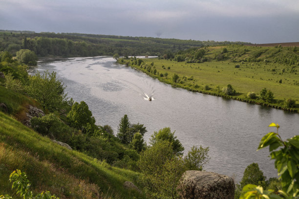 在自然保护区，一艘快速行驶的摩托艇载着游客俯瞰河流。渔民们坐船去捕鱼。美丽的漂亮的风景。库存图片图片下载